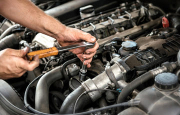 mechanic working car maintenance with soft-focus and over light in the background