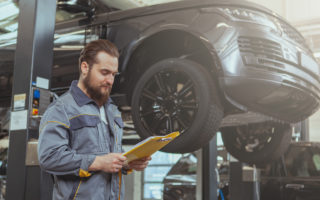 mechanic working car maintenance with soft-focus and over light in the background