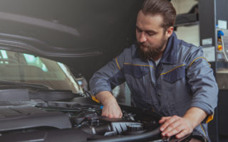 mechanic working car maintenance with soft-focus and over light in the background