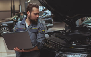 mechanic working car maintenance with soft-focus and over light in the background