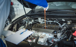 mechanic working car maintenance with soft-focus and over light in the background
